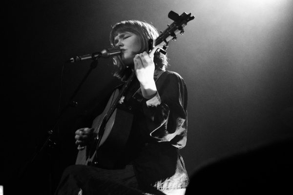Sophie de Munnik op gitaar en aan het zingen op een podium