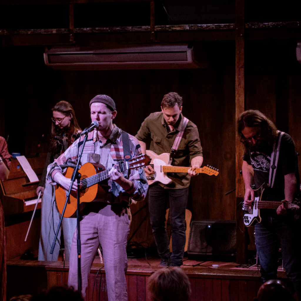 Baccus aan het optreden omringd door zijnband