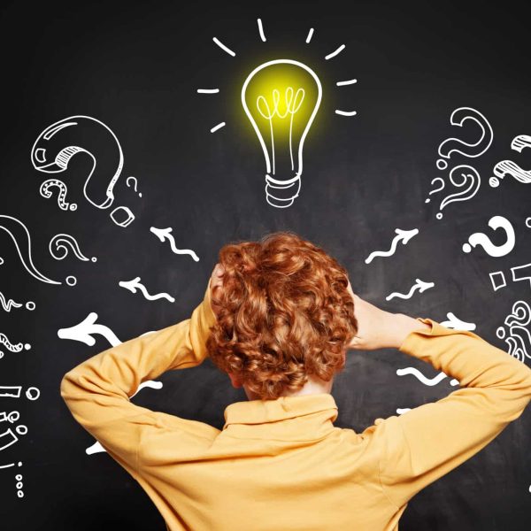 Child and lightbulb on blackboard background